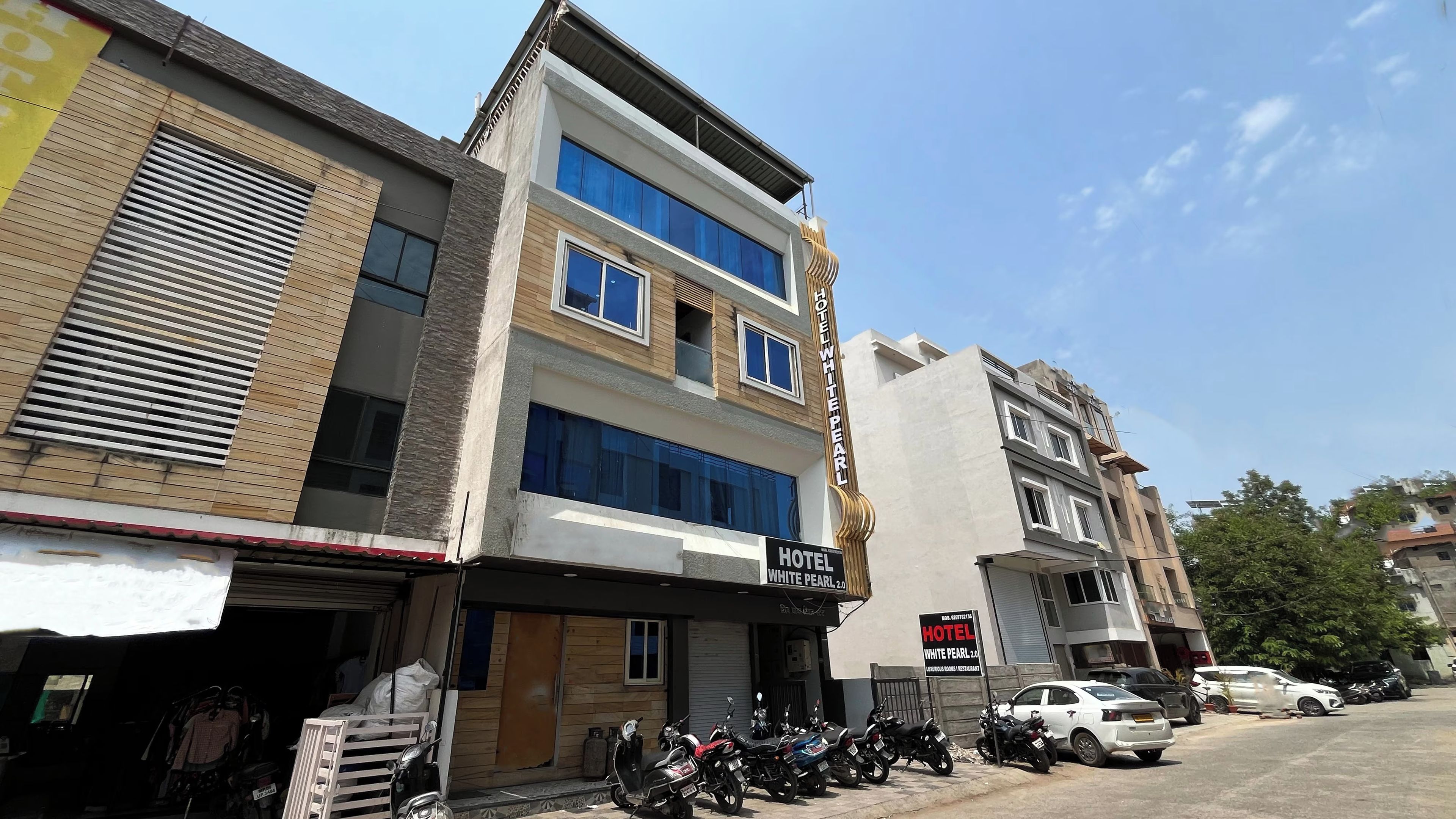 Un edificio de varios pisos con un letrero que indica 'Hotel White Pearl 20', señalando que se trata de un hotel.