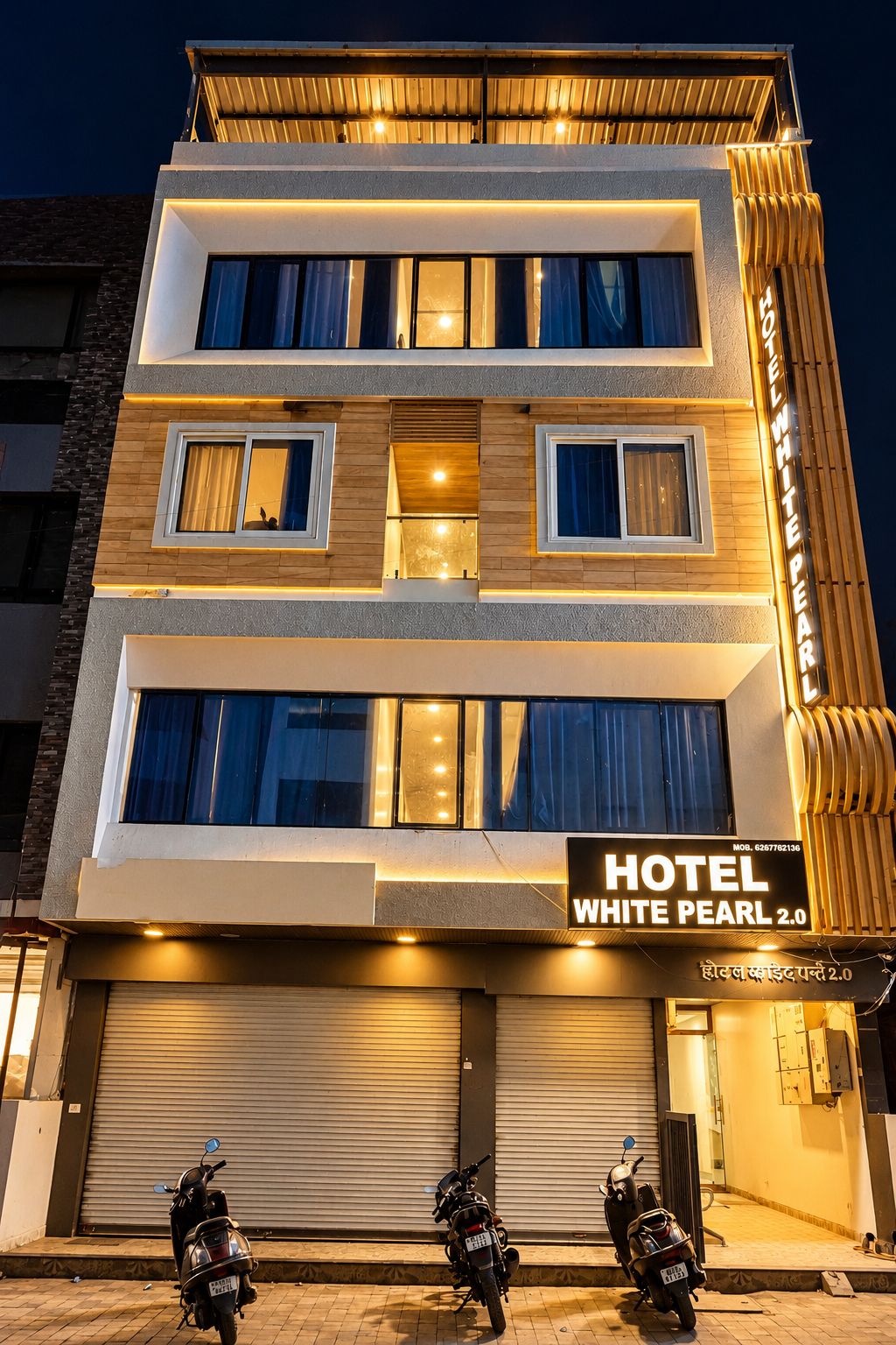 Ett hotell med flera våningar, och en skylt som visar texten ”HOTEL WHITE PEARL 2.0”.