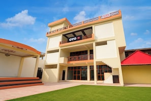 A hotel with a two-story structure, a balcony on the upper floor, and a red-roofed building adjacent to it. - Hotel O Ganeshpur Inn (Lucknow)