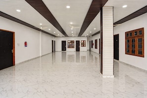 A spacious hallway with a polished marble floor, wooden doors, and ceiling fans. - Hotel O Ganeshpur Inn (Lucknow)