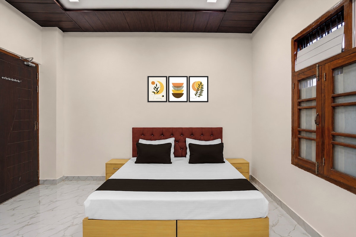Un dormitorio con una cama, dos mesitas de noche, un armario y una ventana con vistas.