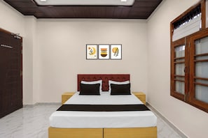 Un dormitorio con una cama, dos mesitas de noche, un armario y una ventana con vistas.