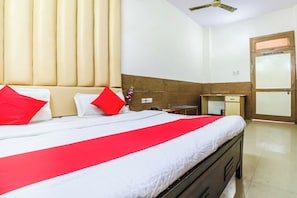 A hotel room with a bed, a nightstand, a desk, a chair, a wardrobe, and a door. - Hotel O Prem Chunaria (Moradabad)