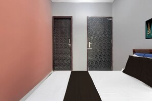 Un dormitori amb un llit, dues portes i una obra d'art penjada a la paret.