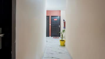 A hallway with a marble floor leading to a door labeled 'ROOM-10'.
