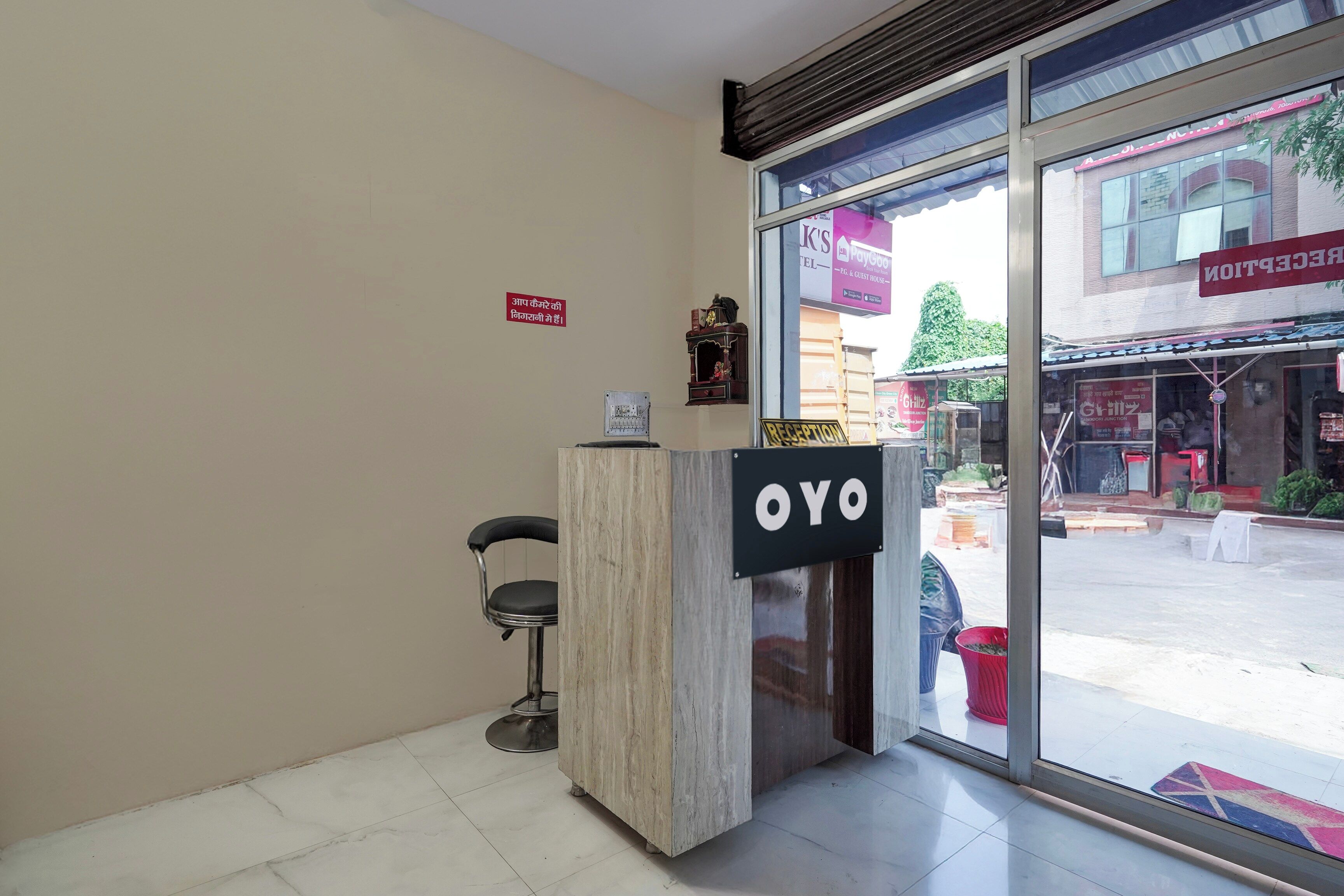 Un mostrador de recepción con un cartel que dice 'OYO' en el vestíbulo de un hotel.