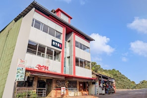 Een gebouw met twee verdiepingen met borden waarop 'OYO HOTEL' en 'HOTEL MAHABALESHWAR EXECUTIVE' staan.
