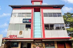 A hotel building with multiple floors, large windows, and signage for 'OYO' and 'HOTEL RAMA EXECUTIVE'. - Hotel O Rama Executive (Mahabaleshwar)