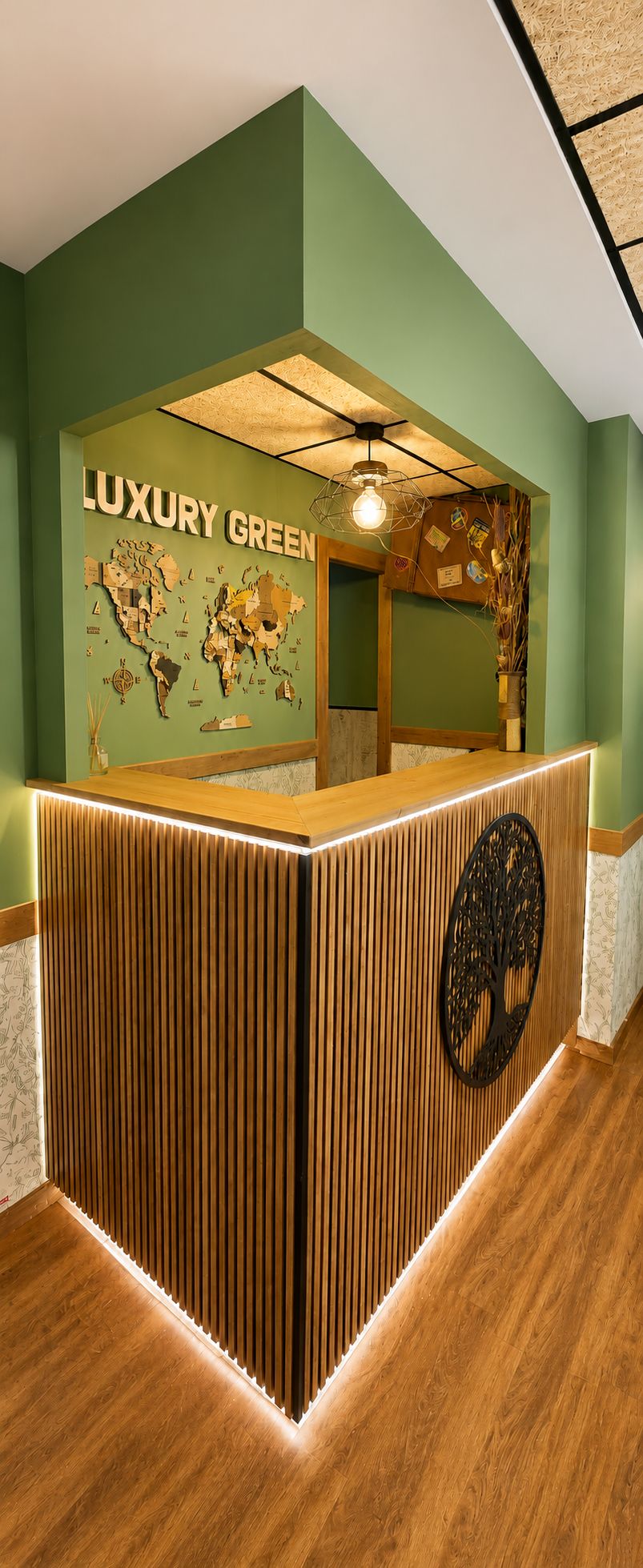 A reception desk with a world map and the text 'LUXURY GREEN' on the wall.