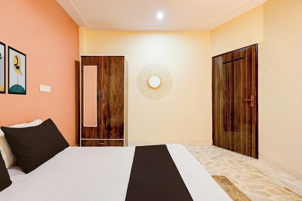 A bedroom with a bed, a wardrobe, a mirror, and a wall decoration. - Hotel O New Star Hotel (Gurugram)