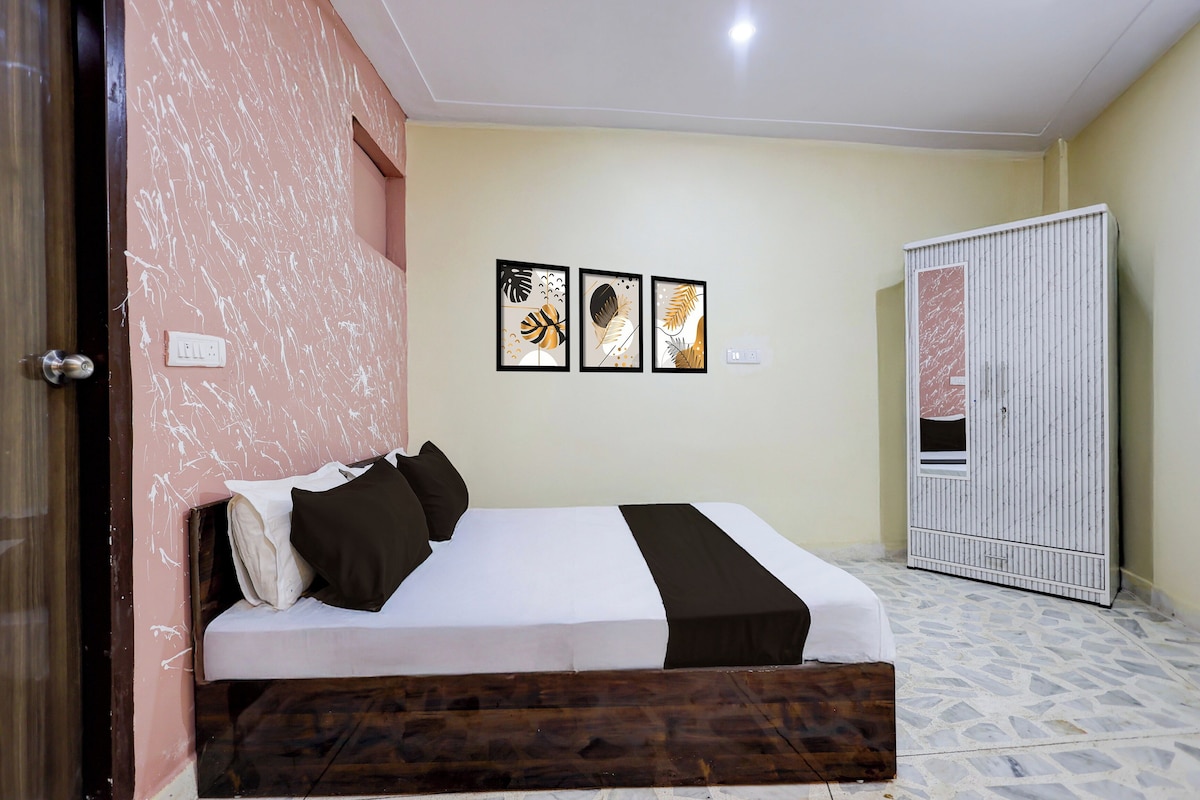 Un dormitorio con una cama, un armario y tres cuadros en la pared.