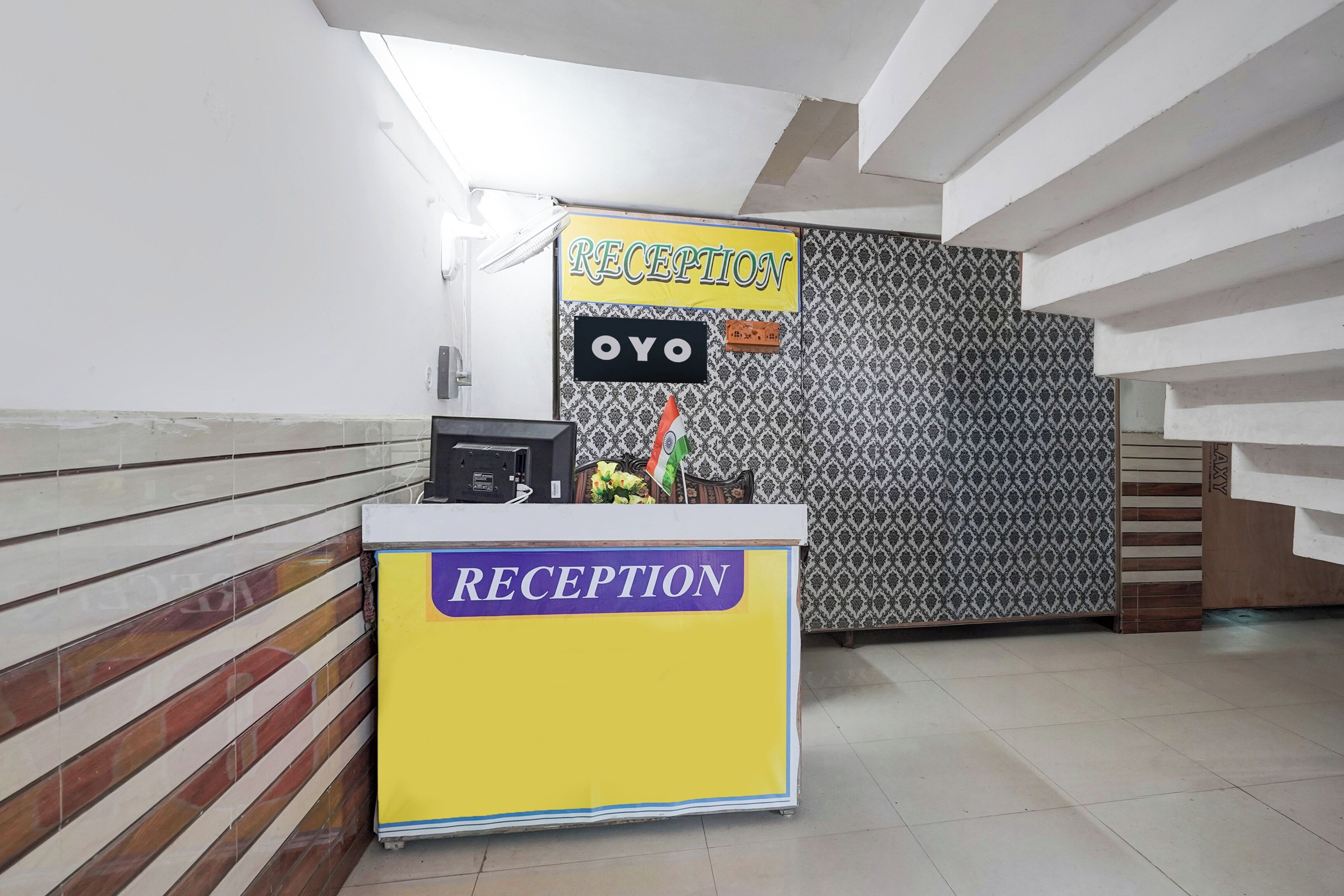 Un mostrador de recepción con un cartel que dice 'RECEPTION' y 'OYO'.