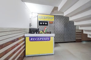 Un mostrador de recepción con un cartel que dice 'RECEPTION' y 'OYO'.
