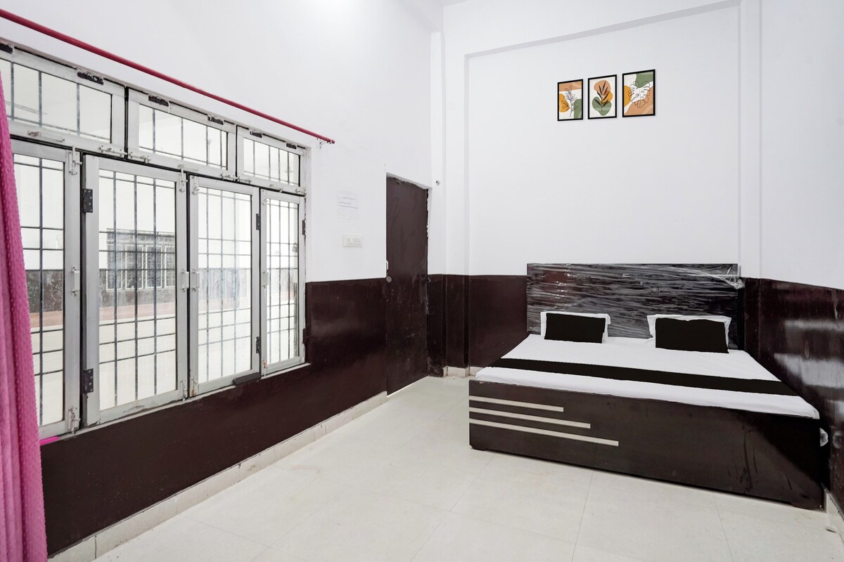 A bedroom with a bed, a window with metal bars, and a door.