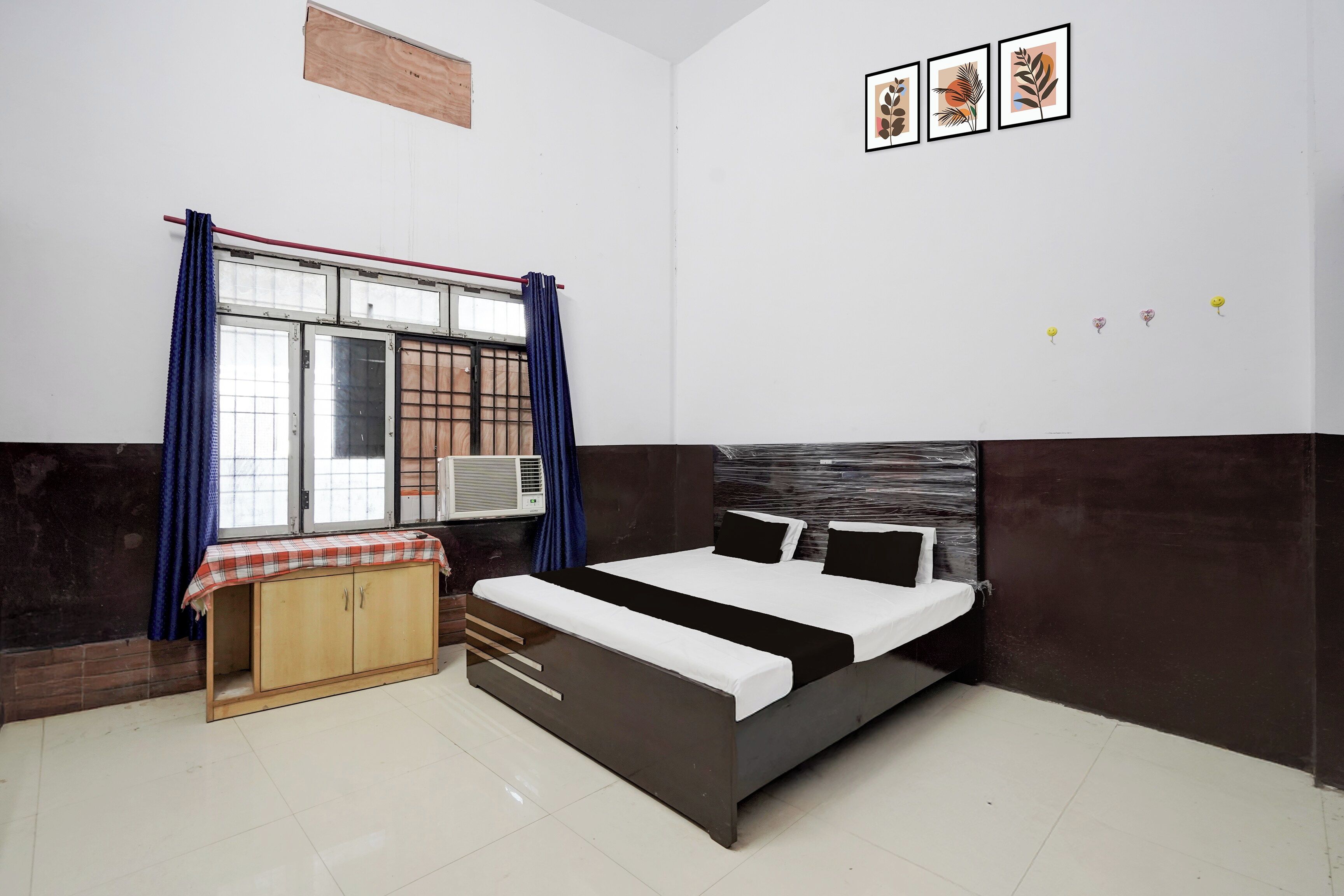 Un dormitorio con cama, armario, ventana con cortinas y decoración en la pared.