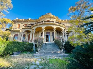 A grand building with a central dome, multiple arches, and a staircase leading to the entrance. - New Listing (Sanremo)