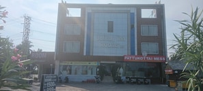 A building with a sign for 'Joliday Inn' and 'Pattukottai Mess' indicating a hotel and mess.