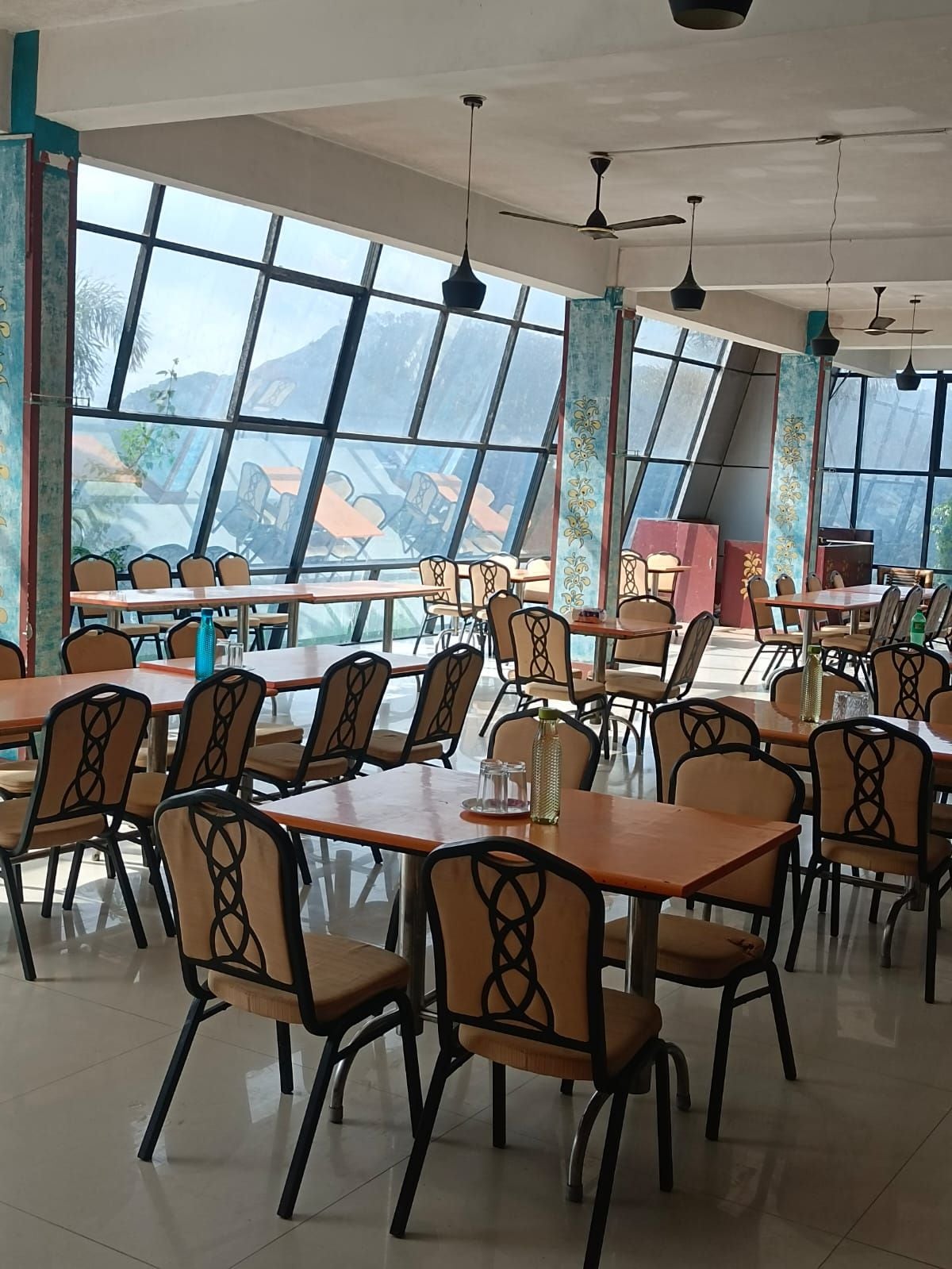 Un vaste espace dédié à la salle à manger, doté de hauts plafonds, de grandes fenêtres et de mobilier moderne.