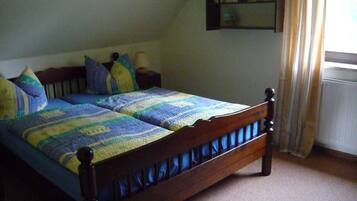 A bed with a wooden frame and a blue and yellow quilt.