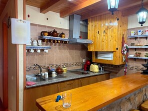 Eine Küche mit Holzausstattung, einer Arbeitsplatte aus Granit und verschiedenen Küchenutensilien.