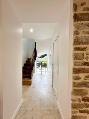 A hallway with a staircase, a potted plant, and a door. - Holiday Home 'Grand Gîte De Standing 14 Pers' with Private Terrace, Private Garden and Wi-Fi (Alençon)