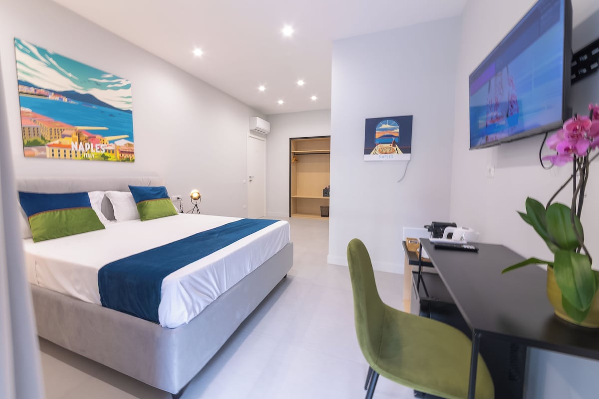 Een moderne hotelkamer met een bed, een bureau, een stoel en kunst aan de wanden.
