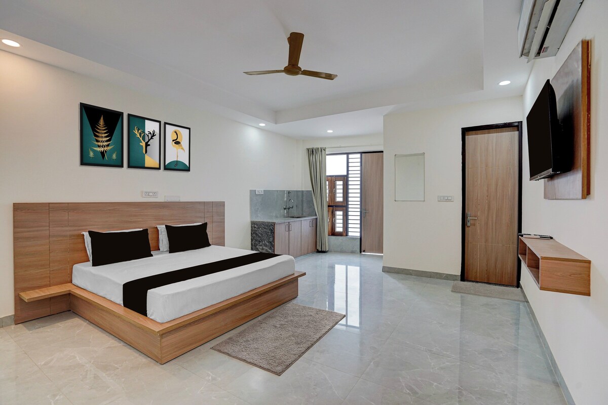 A modern bedroom with a large bed, a ceiling fan, and artwork on the wall.