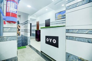 A reception area with a marble wall, a reception desk, and a framed picture on the wall. - Hotel O by OYO Stay inn Classic Hotel (Mohali)