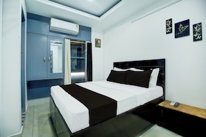 A hotel room with a bed, a wardrobe, a window with curtains, and wall art. - Hotel O by OYO Stay inn Classic Hotel (Mohali)