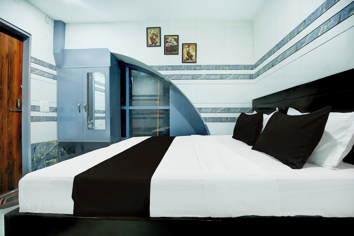 A hotel room with a large bed, a wardrobe, a bathroom, and a staircase.