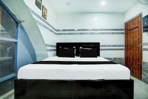 A hotel room with a bed, a wooden door, and a window. - Hotel O by OYO Stay inn Classic Hotel (Mohali)