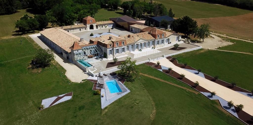 Un vaste domaine comprenant plusieurs bâtiments, une piscine et des jardins aménagés.