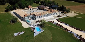 A large estate with multiple buildings, a swimming pool, and landscaped gardens.