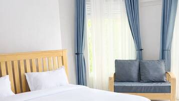 Une chambre à coucher avec un lit en bois, un canapé gris et des rideaux bleus.