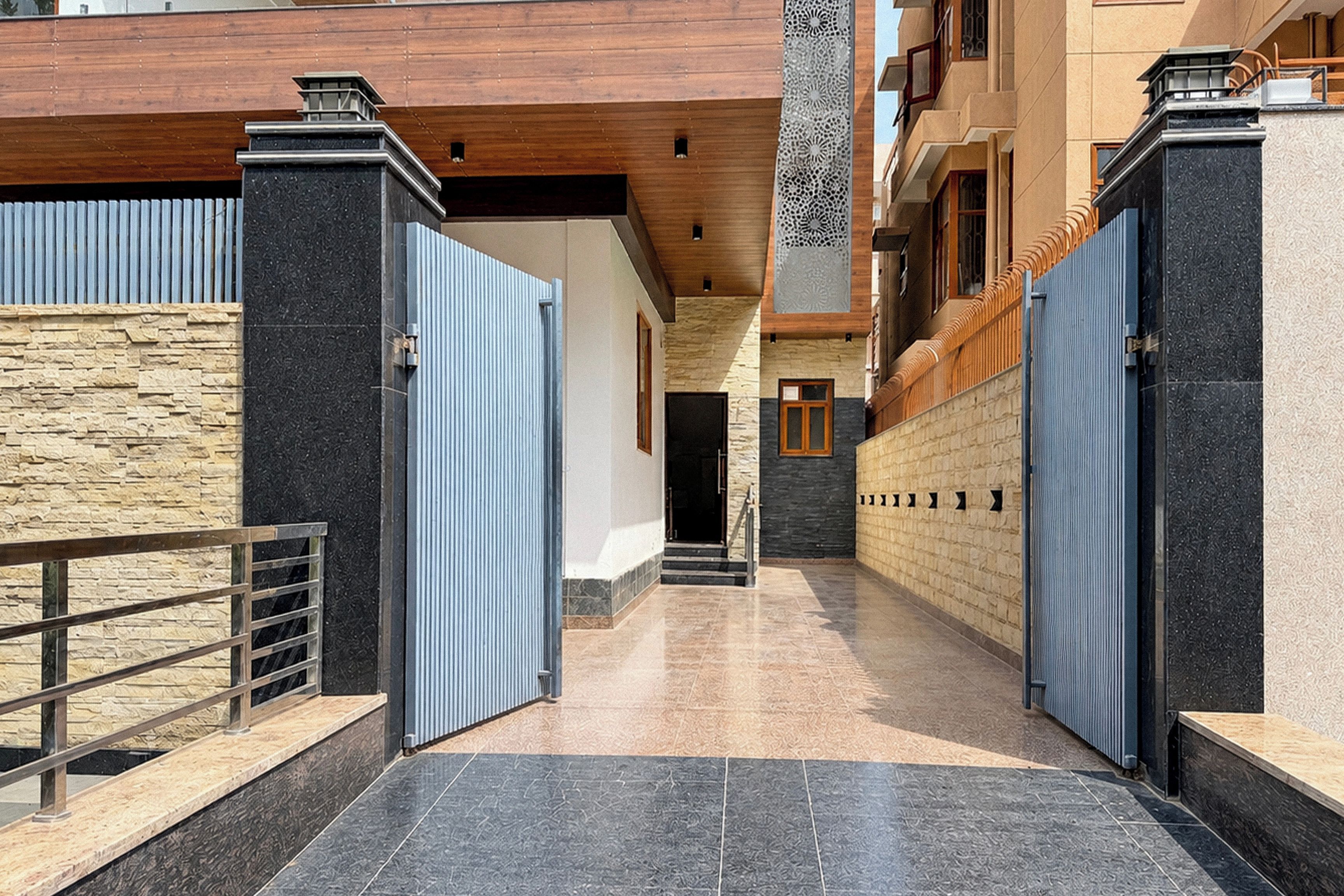 A gated entrance with a stone wall and a metal gate.
