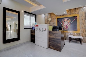 A reception area with a marble wall, a framed religious painting, a 'No Smoking' sign, and a reception desk. - Hotel O Krupa Lodge (Pune)