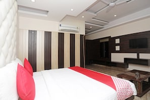 A hotel room with a bed, a TV mounted on the wall, and a ceiling fan. - Hotel O Subhadra Residency (Meerut)