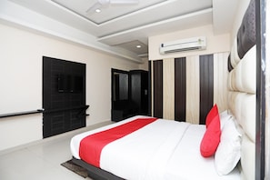 A modern hotel room with a large bed, a flat-screen TV mounted on the wall, and a ceiling fan. - Hotel O Subhadra Residency (Meerut)