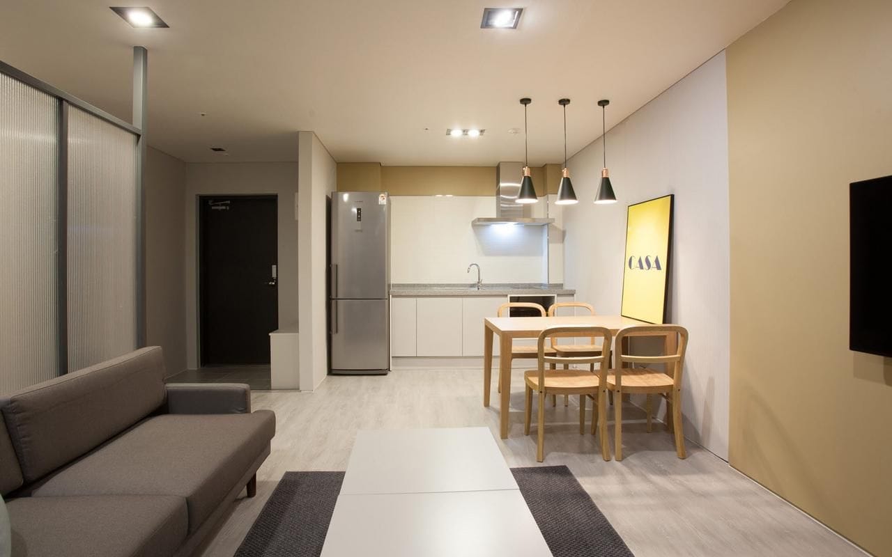 Une cuisine moderne avec un coin repas, un canapé et un téléviseur à écran plat.