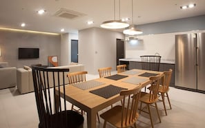 Una cocina moderna con comedor, electrodomésticos de acero inoxidable y un televisor de pantalla plana.