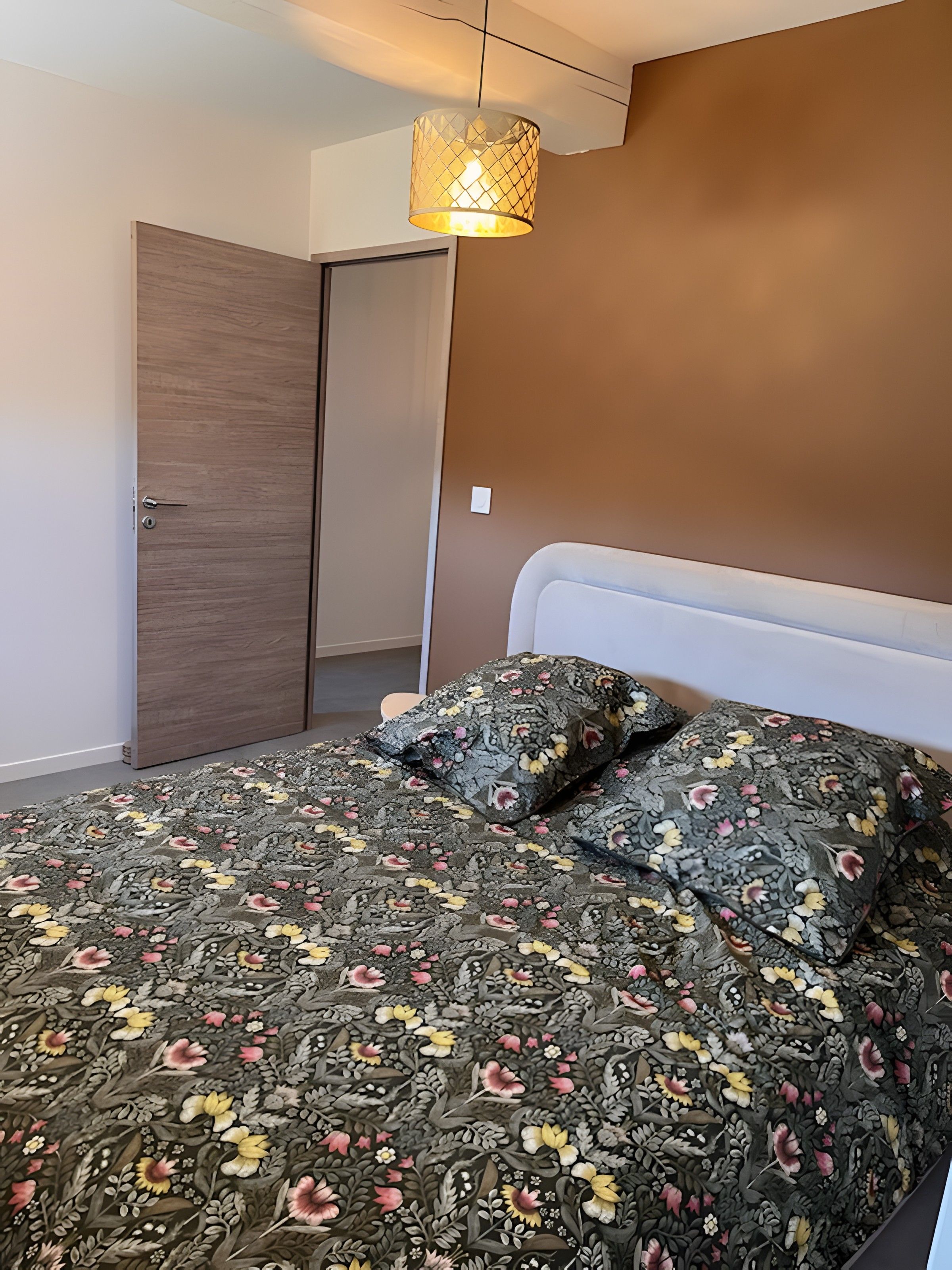 Una camera da letto con un letto, una porta e un lampadario.