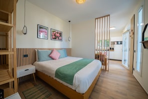 Una camera da letto moderna con un letto in legno, un comodino, due quadri appesi alla parete e una coperta verde.