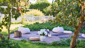 An outdoor seating area with bean bags, a woven basket, and a vase of flowers.
