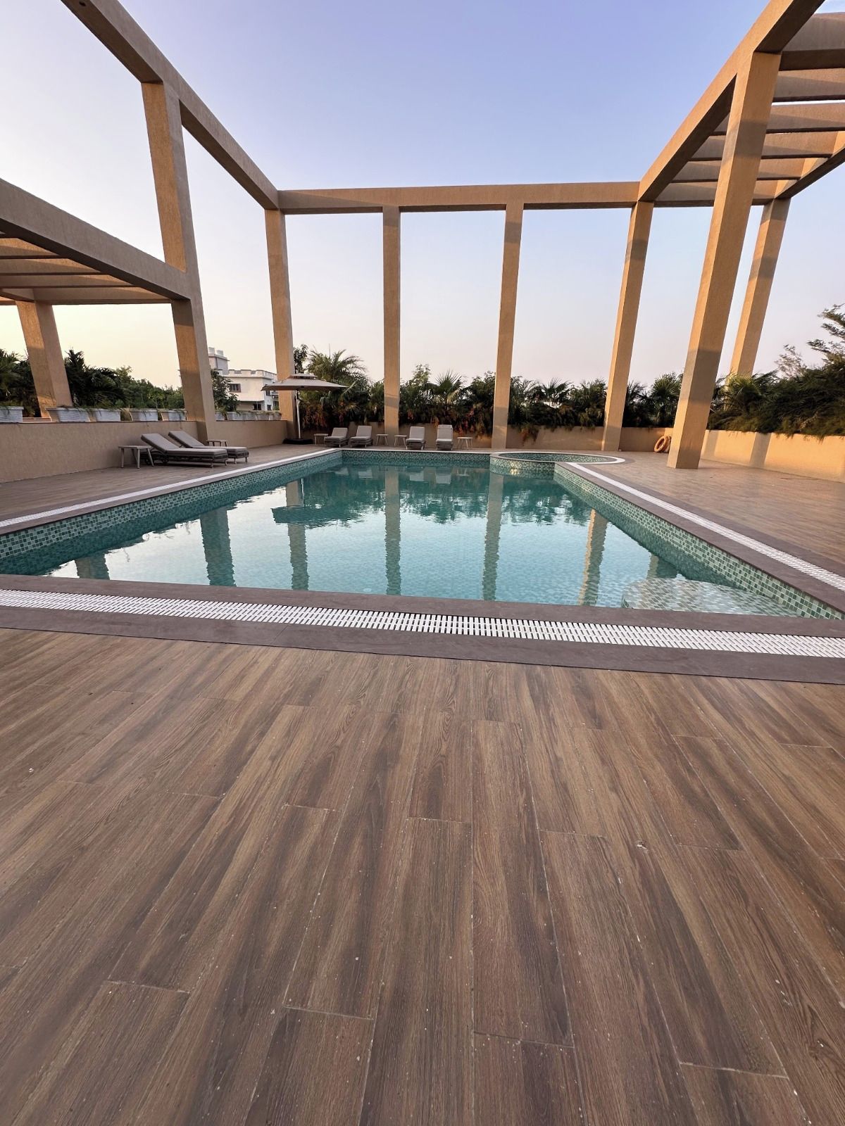 A swimming pool with lounge chairs and a wooden deck.
