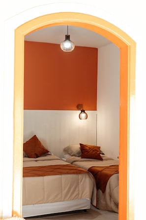A room with two beds, a wooden-framed archway, and a ceiling light fixture. - Hotel Aguas do Rio Grande (Orindiúva)