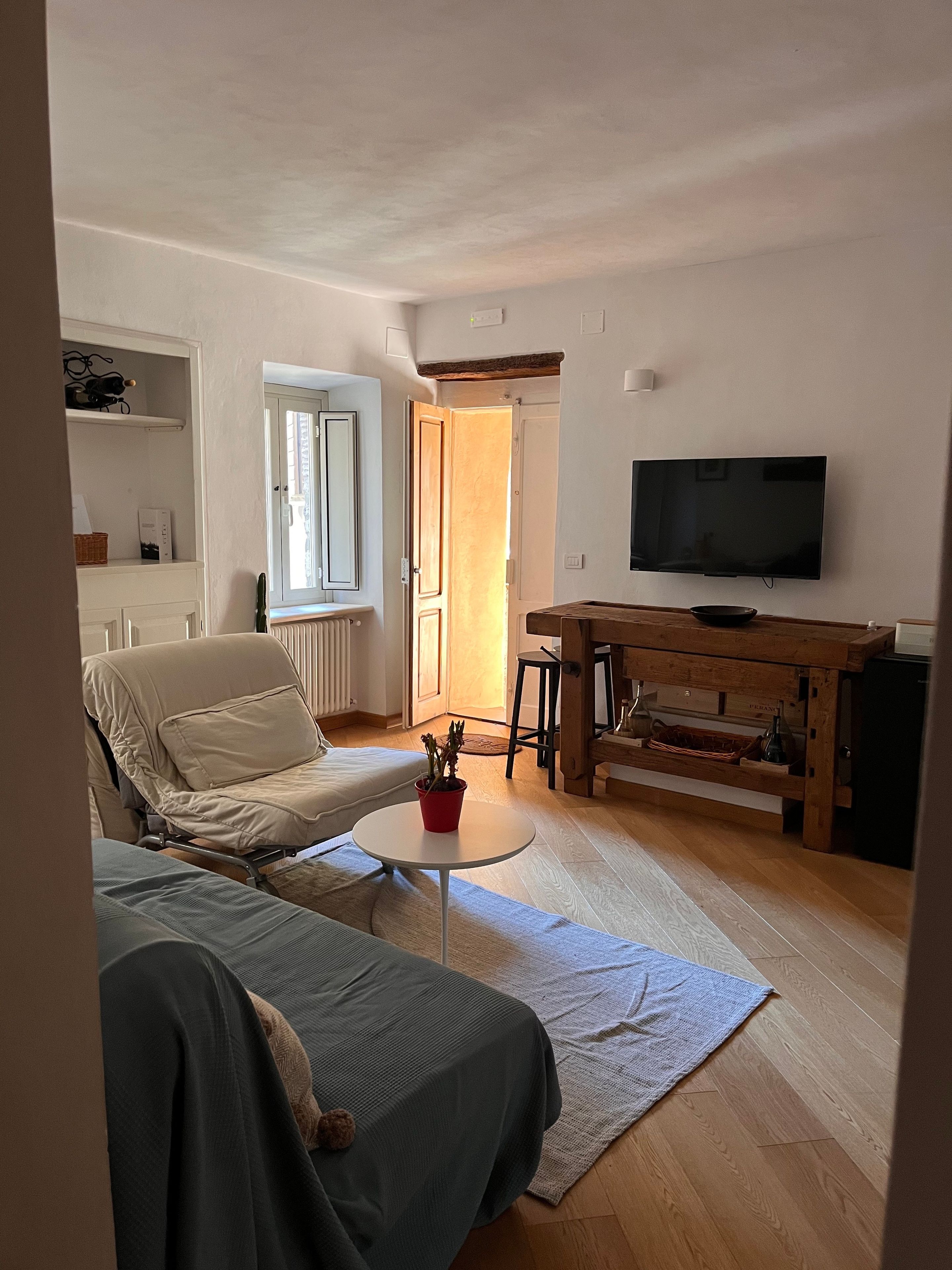 Ein Wohnzimmer mit Sofa, Couchtisch, Fernseher und Holzschrank.