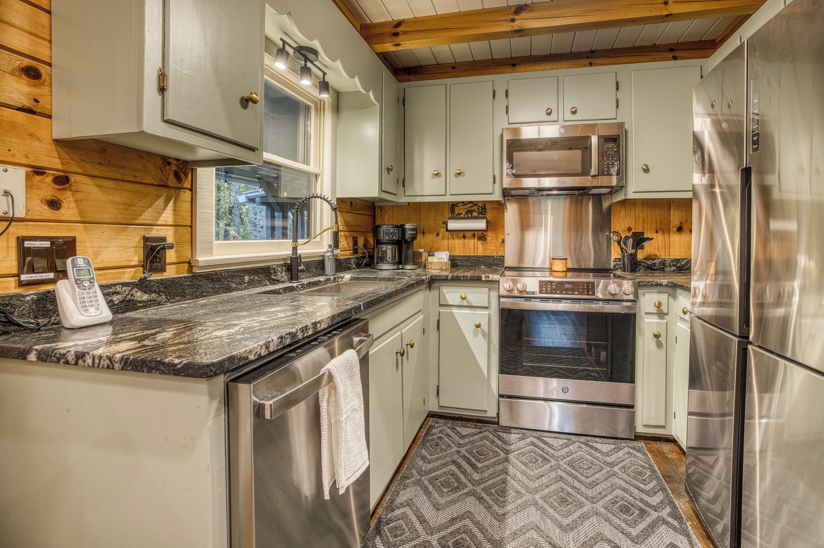 A modern kitchen with stainless steel appliances, a built-in microwave, and a coffee maker.