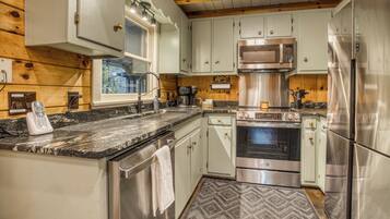 A modern kitchen with stainless steel appliances, a built-in microwave, and a coffee maker.