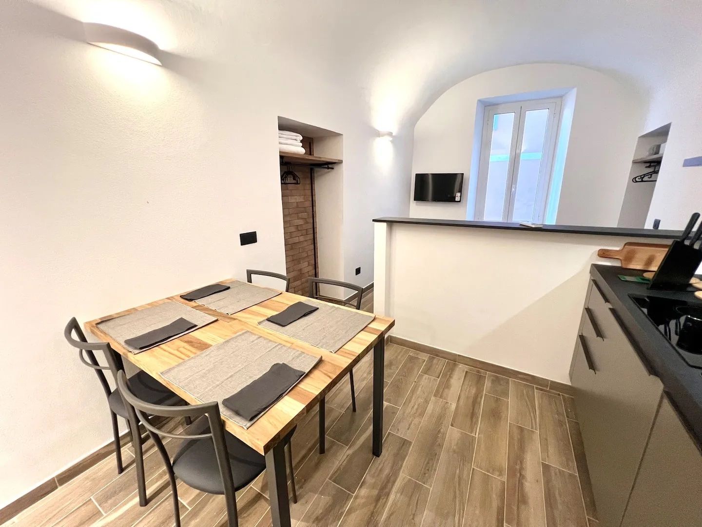 A compact kitchen with a dining area, a built-in stove, and a small window.