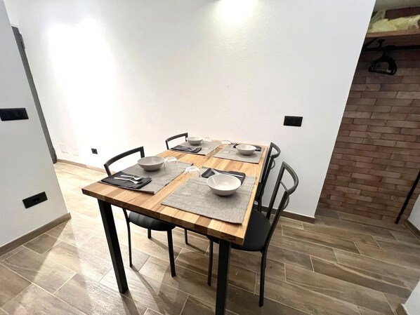 A dining area with a wooden table, black chairs, and grey placemats. - New Listing (Sanremo)